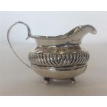 A Georgian silver cream jug with gadroon rim on ba