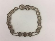 An unusual Chinese silver belt mounted with numerous circ