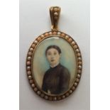A large oval gold portrait miniature of a lady wit