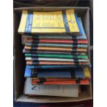 A box containing numerous Penguin and other books.