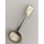 A heavy fiddle pattern silver sifter spoon with crested a