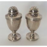 A pair of Edwardian silver peppers with reeded rims. Lond