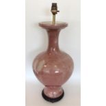 A massive peach coloured vase on hard wood stand o