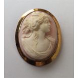 A 9 carat oval coral cameo of a lady in gold twist