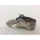 A large silver pin cushion in the form of a shoe. Birming