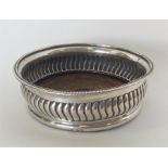 A Georgian silver half fluted wine coaster with mahogany