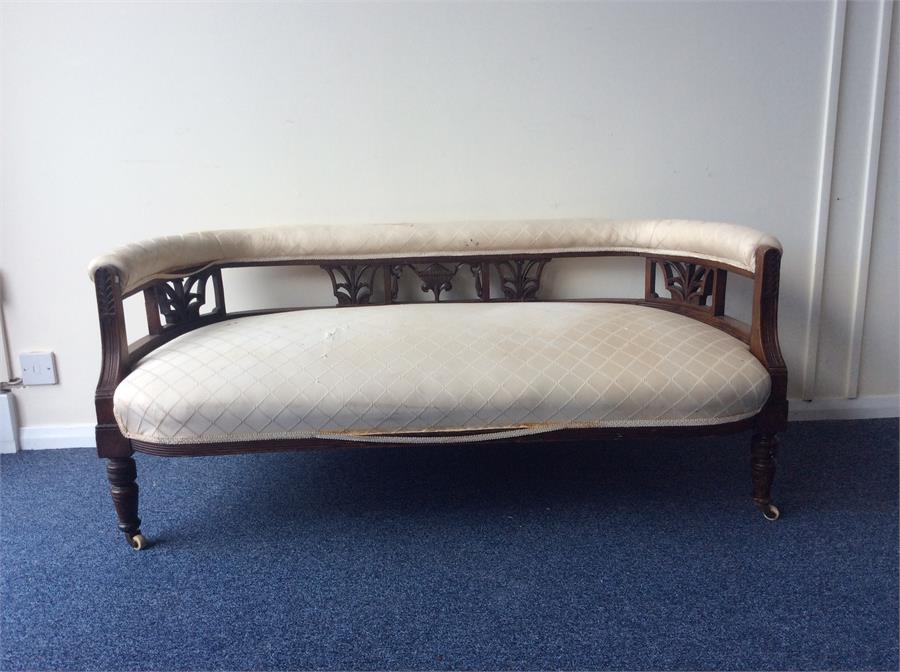 An Edwardian mahogany bow back settee on turned su