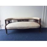 An Edwardian mahogany bow back settee on turned su