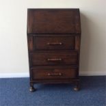 An oak bureau of Art Deco form with three drawers.