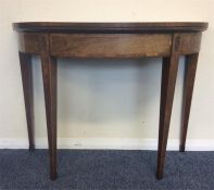 A mahogany Demi Lune card table with hinged top on
