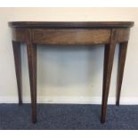 A mahogany Demi Lune card table with hinged top on