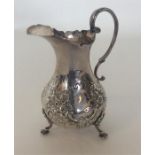 A 19th Century embossed silver cream jug with cres