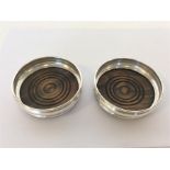 A pair of modern small silver mounted coasters wit