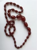A long graduated string of red amber beads. Approx