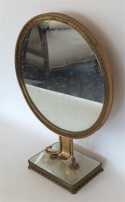 A stylish mirror on brass mounted base. Est. £30 -