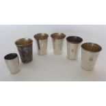 A heavy set of 5 +1 Sterling silver goblets of plain desi