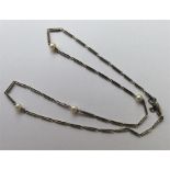 A platinum and pearl chain with barrel clasp. Appr