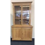 A large pine two part bookcase with glazed doors.