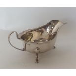 An Edwardian silver sauce boat with card cut rim on cabri