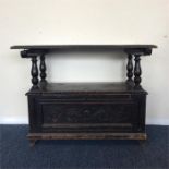 A small oak panelled settle with hinged top. Est.