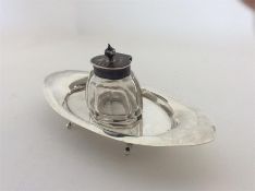 A boat shaped silver inkwell on four bracket feet.