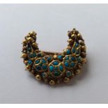 A heavy gold brooch in the form of a crescent inse