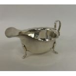 A card cut silver sauce boat on three cabriole leg