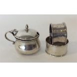 A silver mustard and two silver napkin rings. Lond