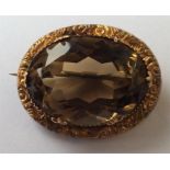 A 9 carat mounted oval citrine brooch with scroll