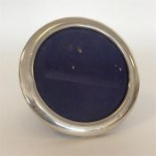 A circular modern silver picture frame with velvet decora