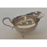 A small silver sauce boat with card cut rim and reeded su