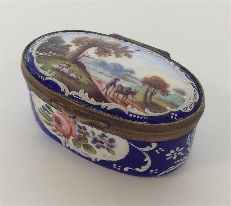 An attractive enamelled pill box with brass mounts
