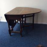 A Georgian oak drop leaf table on turned supports.