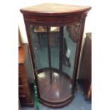 A mahogany bow fronted corner display cabinet on p