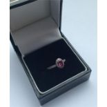 A ruby and diamond oval cluster ring in 18 carat m