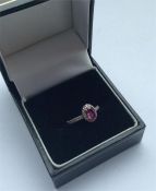 A ruby and diamond oval cluster ring in 18 carat m