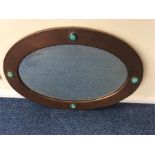 A stylish copper framed mirror with enamelled deco