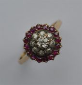 A circular ruby and diamond cluster ring in gold m