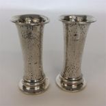 A pair of tapering silver spill vases of hammered form. B