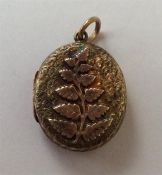 An attractive gold locket decorated with flowers a