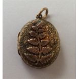An attractive gold locket decorated with flowers a