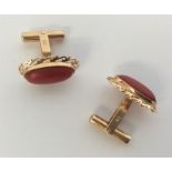 A pair of 18 carat and coral cufflinks.