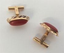 A pair of 18 carat and coral cufflinks.
