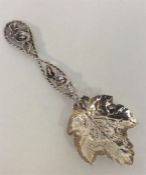 A Continental silver caddy spoon with leaves, flow