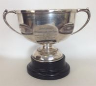 A heavy silver trophy cup with panelled sides on p