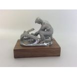 A small silver model of a kneeling gent on wooden