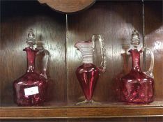 Three pieces of cranberry glass.