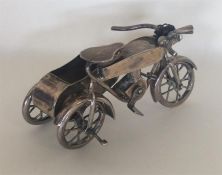 An unusual silver motor bike and side car with spo