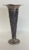 An embossed silver spill vase decorated with flowe