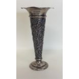 An embossed silver spill vase decorated with flowe
